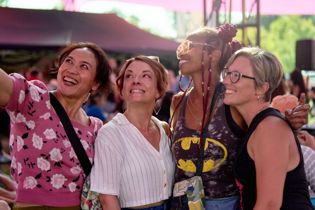 group of 4 ladies smiling as they take a group selfie together