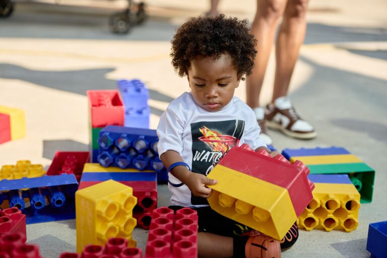 young child playing with large legos in the kid zone